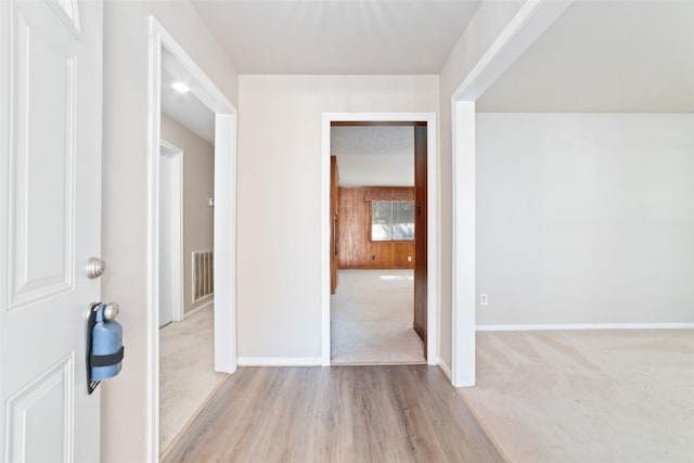 carpeted foyer with wooden walls