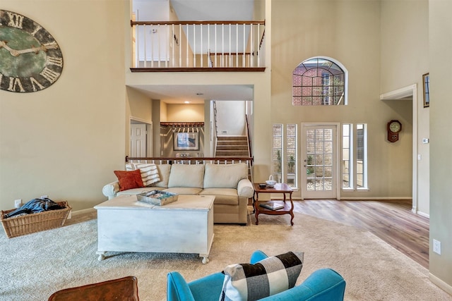 living room featuring light hardwood / wood-style floors and a high ceiling