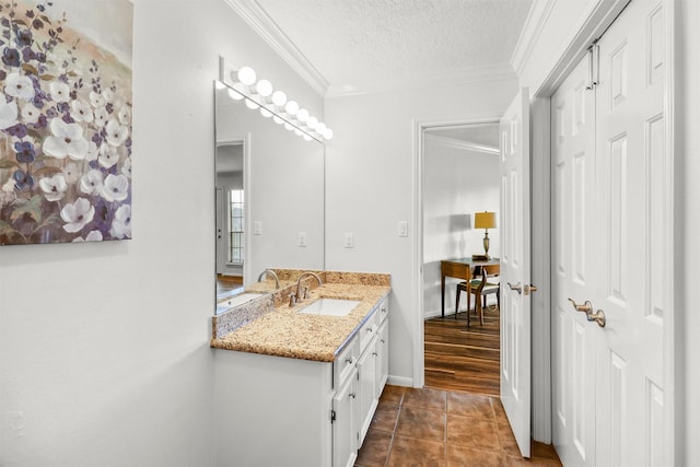 bathroom with crown molding, vanity, tile patterned flooring, and a textured ceiling