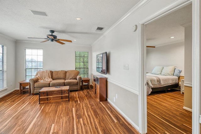 living room featuring crown molding, ceiling fan, dark hardwood / wood-style floors, and a textured ceiling