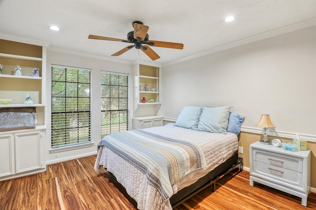 bedroom with crown molding, hardwood / wood-style floors, and ceiling fan