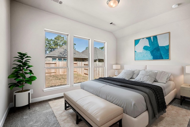 bedroom featuring light carpet and lofted ceiling