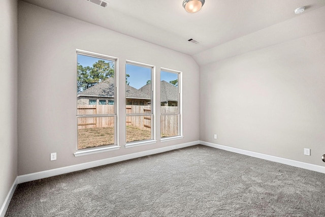 carpeted empty room featuring vaulted ceiling