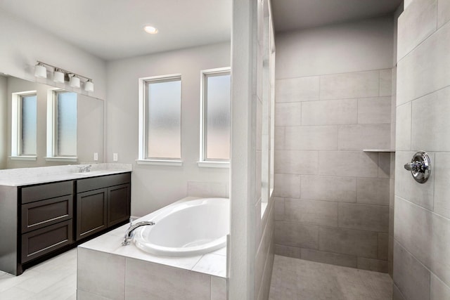 bathroom with vanity and shower with separate bathtub