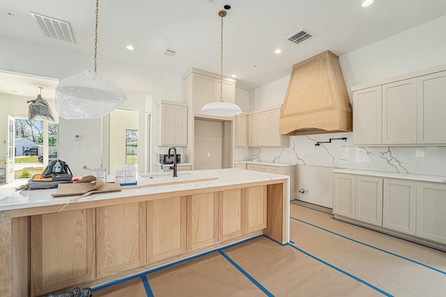 kitchen featuring decorative backsplash, decorative light fixtures, sink, and custom range hood