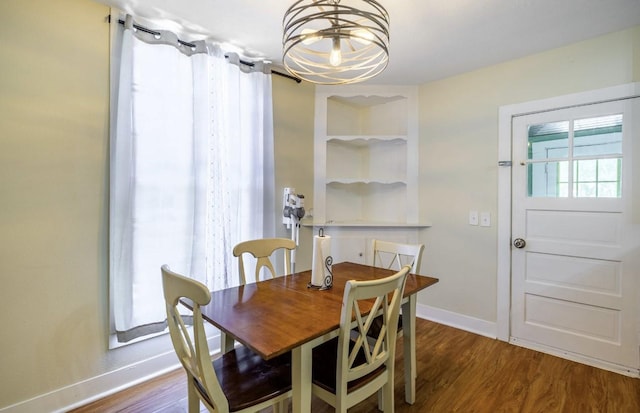 dining space with hardwood / wood-style flooring and an inviting chandelier