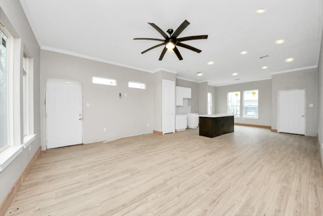 unfurnished living room with crown molding, ceiling fan, and light hardwood / wood-style floors