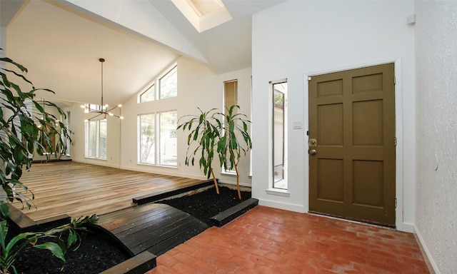 foyer entrance with wood-type flooring, a chandelier, and high vaulted ceiling