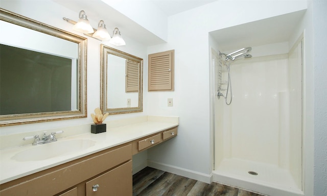 bathroom featuring vanity, wood-type flooring, and a shower