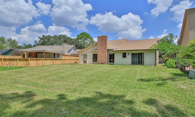 rear view of house featuring a lawn