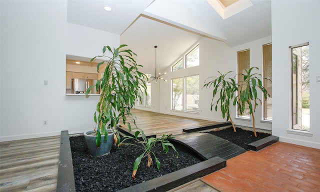 foyer entrance featuring high vaulted ceiling, a chandelier, and hardwood / wood-style floors