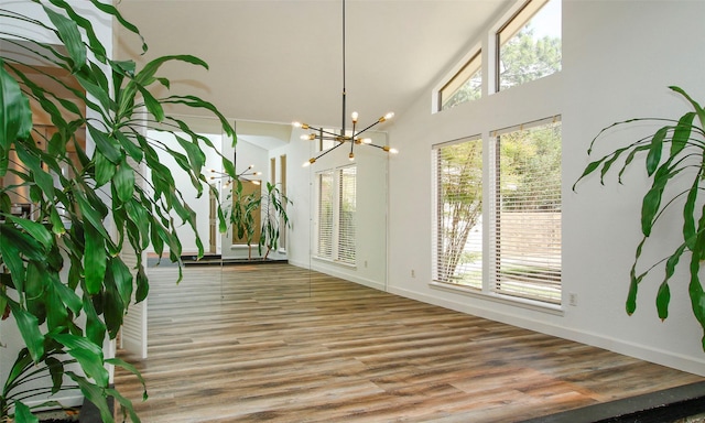 sunroom with lofted ceiling and an inviting chandelier