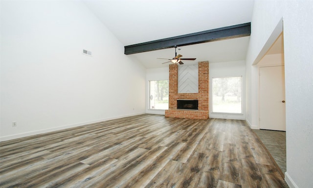 unfurnished living room featuring beamed ceiling, ceiling fan, wood-type flooring, and a fireplace