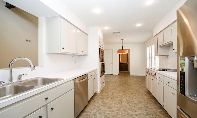 kitchen with appliances with stainless steel finishes, decorative light fixtures, and white cabinets