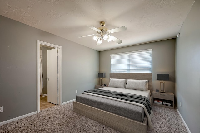 bedroom with ceiling fan, light colored carpet, and a textured ceiling