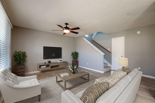 living room featuring hardwood / wood-style flooring, a textured ceiling, and ceiling fan