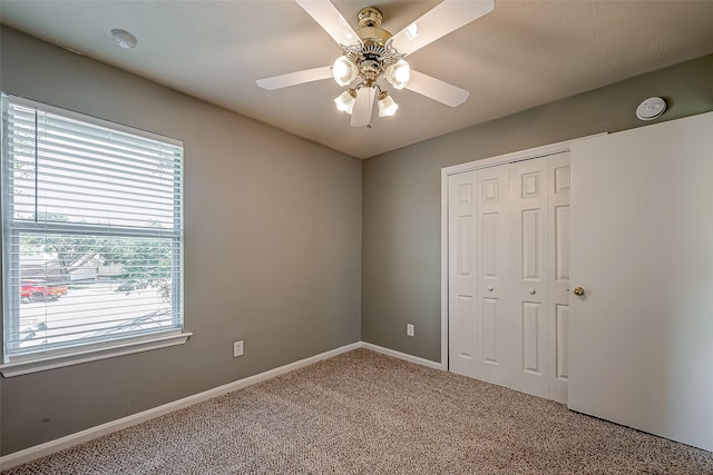 unfurnished bedroom featuring carpet, ceiling fan, and a closet