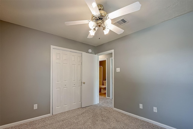 unfurnished bedroom featuring carpet floors, a closet, and ceiling fan