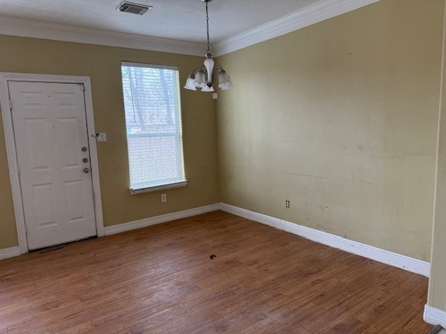 unfurnished dining area with ornamental molding, hardwood / wood-style floors, and a notable chandelier