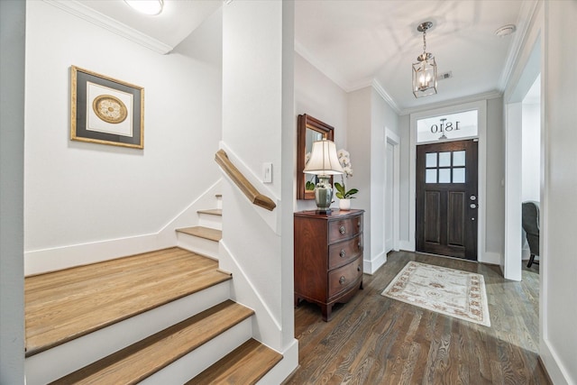 entrance foyer with ornamental molding, dark hardwood / wood-style floors, and a notable chandelier