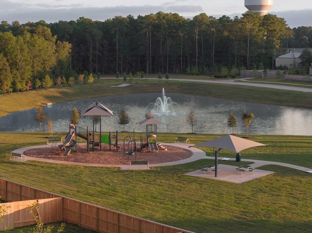 view of community with a playground, a water view, and a yard