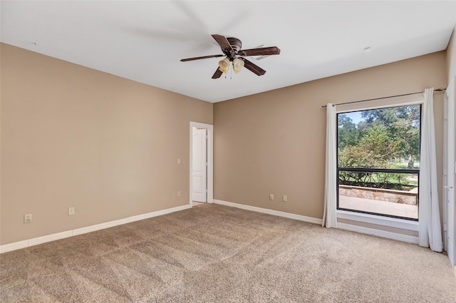 carpeted spare room featuring ceiling fan