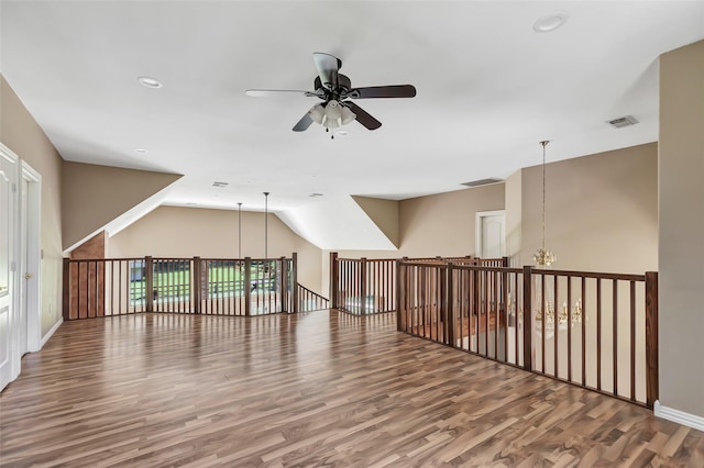 bonus room featuring vaulted ceiling, ceiling fan with notable chandelier, and hardwood / wood-style floors