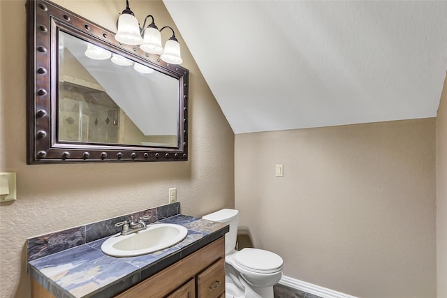 bathroom with vanity, vaulted ceiling, and toilet