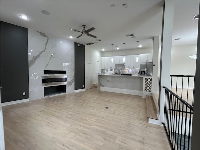 living area with light wood-style floors, visible vents, a ceiling fan, and recessed lighting