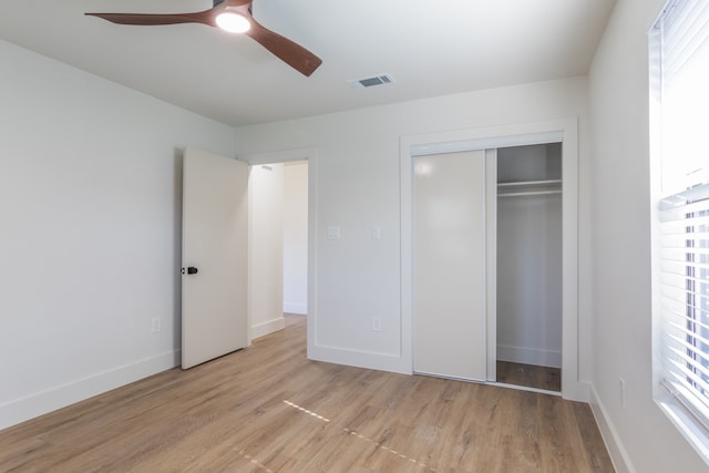 unfurnished bedroom with light hardwood / wood-style floors, a closet, and ceiling fan