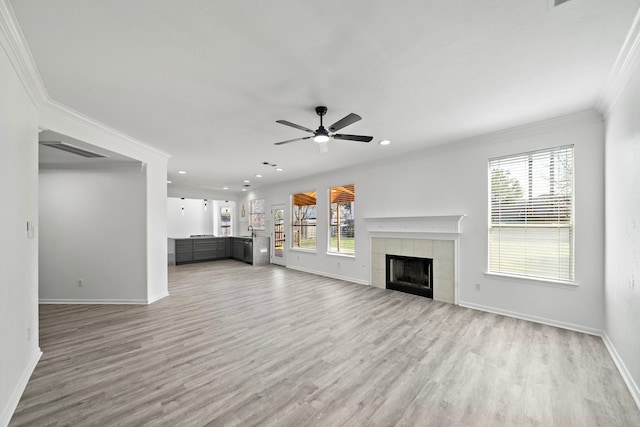 unfurnished living room with light wood-style floors, a fireplace, and a healthy amount of sunlight