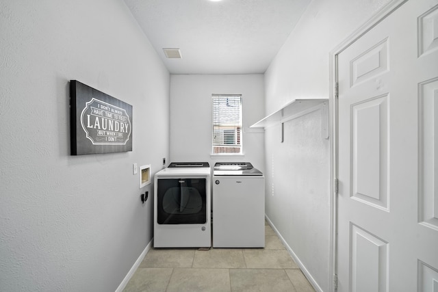 washroom featuring laundry area, light tile patterned flooring, independent washer and dryer, and baseboards