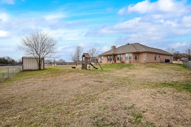 view of yard featuring a storage unit and a playground