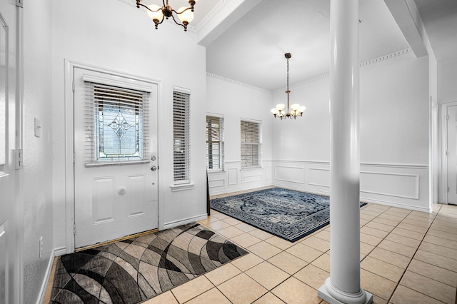 tiled foyer entrance with a notable chandelier and ornamental molding