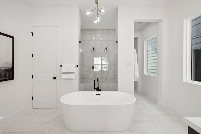 bathroom featuring plus walk in shower, vanity, and a chandelier