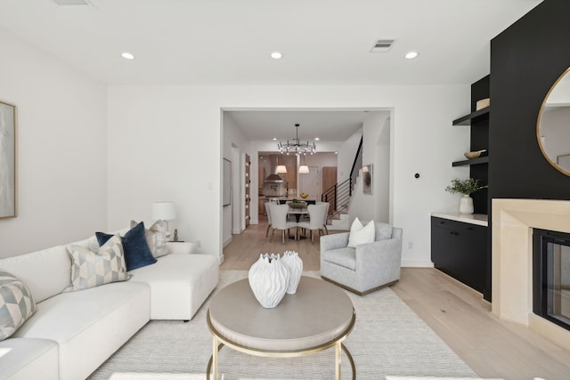 living room featuring an inviting chandelier and light wood-type flooring