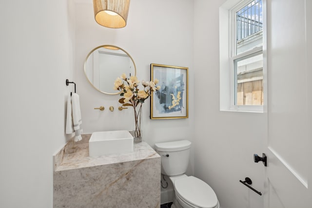 bathroom with plenty of natural light and toilet