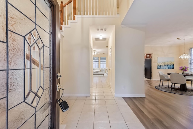 tiled foyer with an inviting chandelier