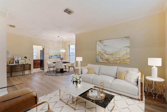 living room featuring a notable chandelier and light hardwood / wood-style flooring