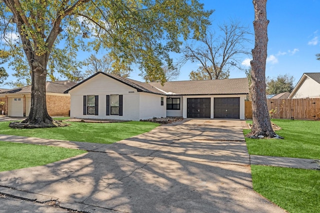 ranch-style house featuring a garage and a front lawn