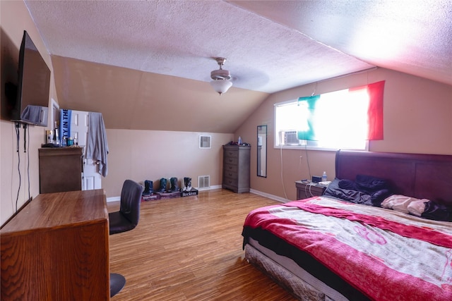 bedroom with hardwood / wood-style flooring, ceiling fan, lofted ceiling, and a textured ceiling