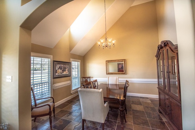 dining space featuring high vaulted ceiling and a chandelier