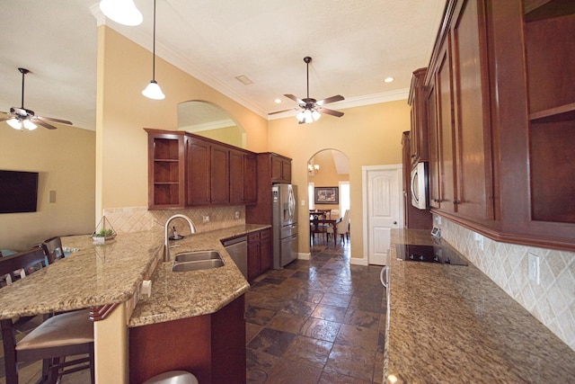 kitchen featuring appliances with stainless steel finishes, sink, a kitchen bar, ceiling fan, and kitchen peninsula