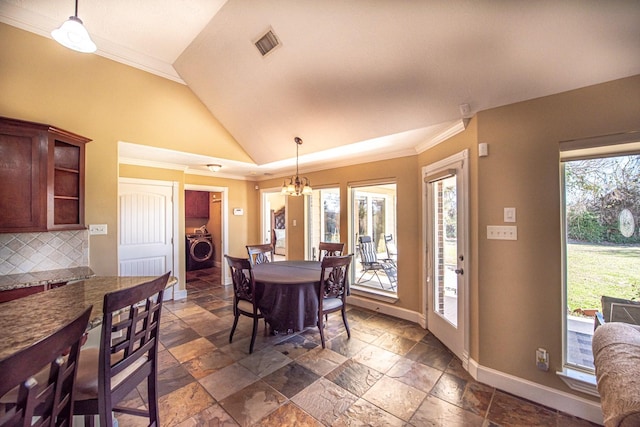 dining area featuring an inviting chandelier, ornamental molding, and washer / dryer