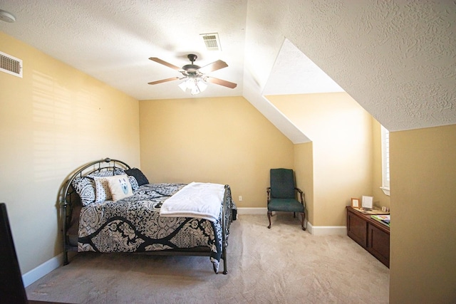 bedroom featuring vaulted ceiling, light colored carpet, ceiling fan, and a textured ceiling