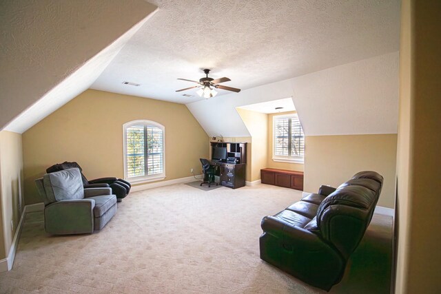 living room featuring ceiling fan, lofted ceiling, carpet, and a textured ceiling