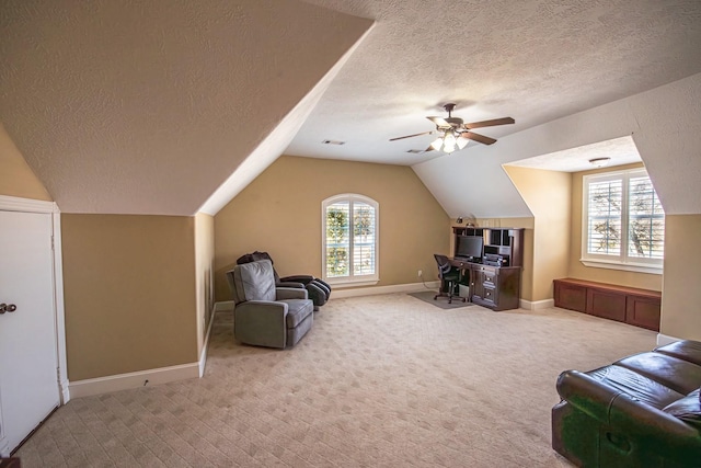 interior space with ceiling fan, light colored carpet, vaulted ceiling, and a textured ceiling