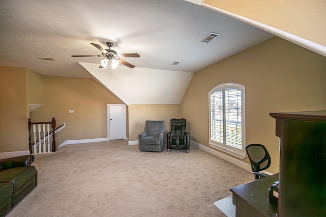 carpeted home office with ceiling fan, lofted ceiling, and a textured ceiling