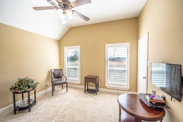 living area featuring vaulted ceiling, light carpet, and ceiling fan