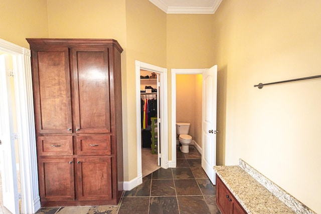 bathroom featuring ornamental molding and toilet